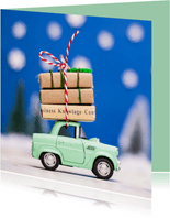 Kerstkaart met een groen autootje dat presentjes vervoert
