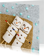 Kerstkaart met marshmallow sneeuwpoppen en sneeuwvlokken