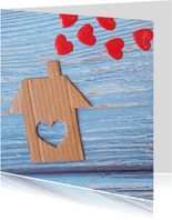 "Nieuw huis" kaart met kartonnen huis en rode harten