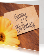 Verjaardagskaart met een gele bloem en een papieren notitie