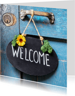 Welkom thuis kaart met krijtbord op een blauwe vintage deur
