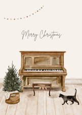 Kerstkaart met piano kerstboom cadeautjes en kat