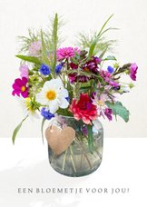 Vrolijke zomaar kaart met een fleurig boeket bloemen in vaas
