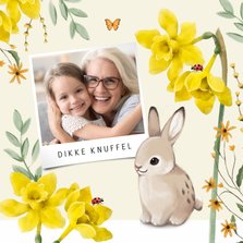 Een vrolijke lente paaskaart met bloemen, vlinders en konijn