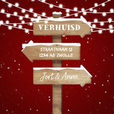 Kerst-verhuiskaart met lampjes, sneeuw en wegwijzerbord