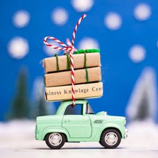 Kerstkaart met een groen autootje dat presentjes vervoert
