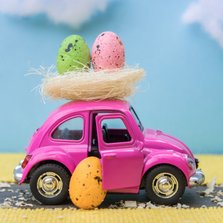 Paaskaart met een roze auto en een nest met paaseieren