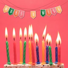 Verjaardagskaart met kleurrijke slinger en cake met kaarsen