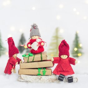 Kerstkaart met drie elfjes in een sneeuwlandschap