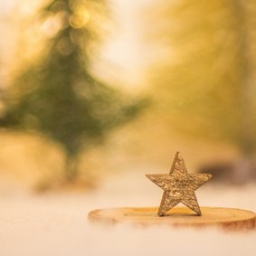 Kerstkaart met een gouden ster in een winterlandschap