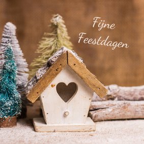 Kerstkaart met houten huisje in een winterlandschap