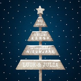 Kerstkaart met sneeuw en houten kerstboom