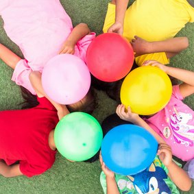 Verjaardagskaart met kids die gekleurde ballonnen vasthouden