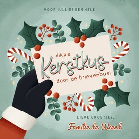 Vrolijke kerstkaart kerstkus door de brievenbus met takjes