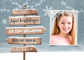 Kerstkaart met winters thema en wegwijzer