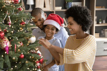 Man vrouw en kind versieren kerstboom