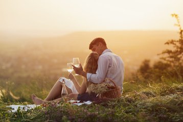 koppel picknickt bij zonsondergang