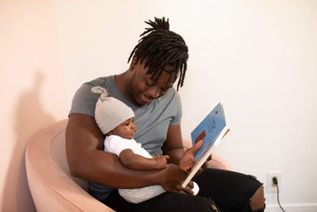 vader leest baby een boekje voor