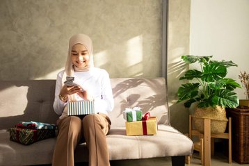vrouw zit op bank met cadeaus