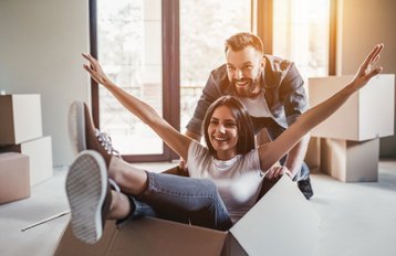 Man staat achter vrouw in verhuisdoos tijdens verhuizing