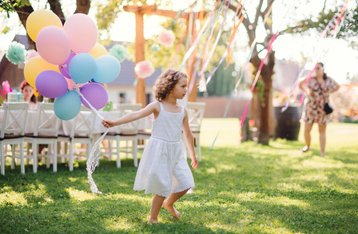 Communiefeest thuis organiseren, meisje met ballonnen