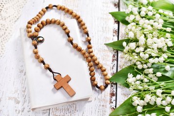 Bijbel met daarop een houten kruis aan een ketting