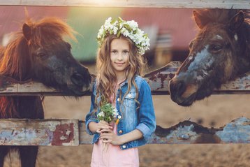 Meisje met paarden op de foto voor communie