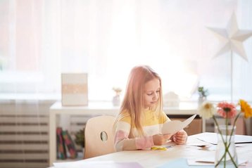 meisje houdt geknipt hart vast aan tafel