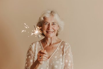 oudere vrouw met sterretjes in haar hand viert oud & nieuw