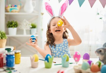 Meisje houdt paasei voor haar gezicht