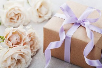 cadeau met lint en beige bloemen ernaast