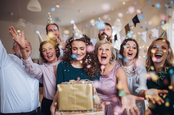 Vrouw omringt door vierende menigte en cadeaus