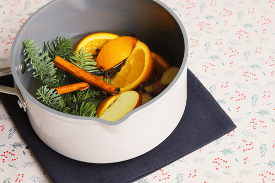 kerstgeur maken: pannetje met kaneel, sinaasappel, dennentakken