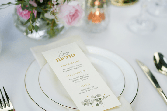 Menukaart met tekst, op een feestelijk aangeklede tafel