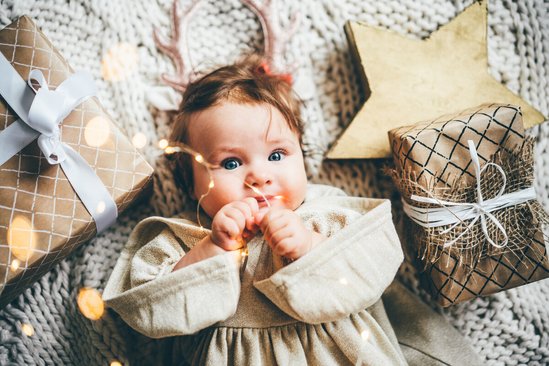 Baby omringd door kerstcadeaus