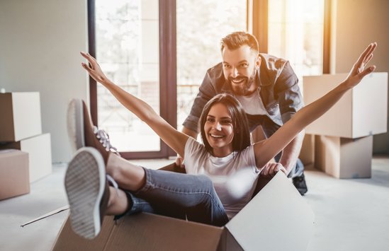 Man en vrouw spelen met verhuisdoos