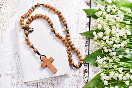 Houten kruis aan een ketting bovenop een Bijbel