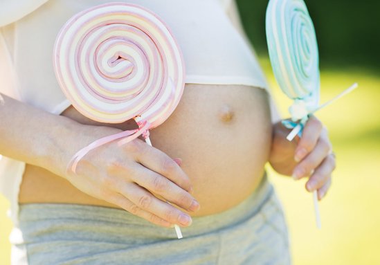 Zwangere vrouw met roze en blauwe lollie voor geslacht wel of niet weten