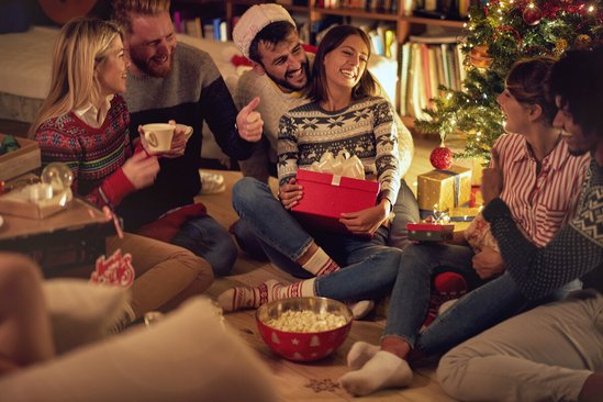 Groep mensen onder de kerstboom met kerstcadeaus