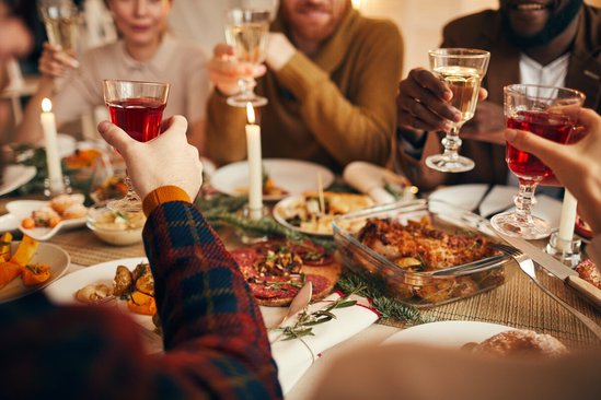 Gedekte kersttafel met gasten die toosten met een glas