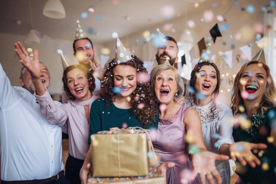 Vrouw omringt door vierende menigte en cadeaus
