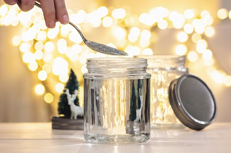 sneeuwbol maken: glitters toevoegen aan het potje