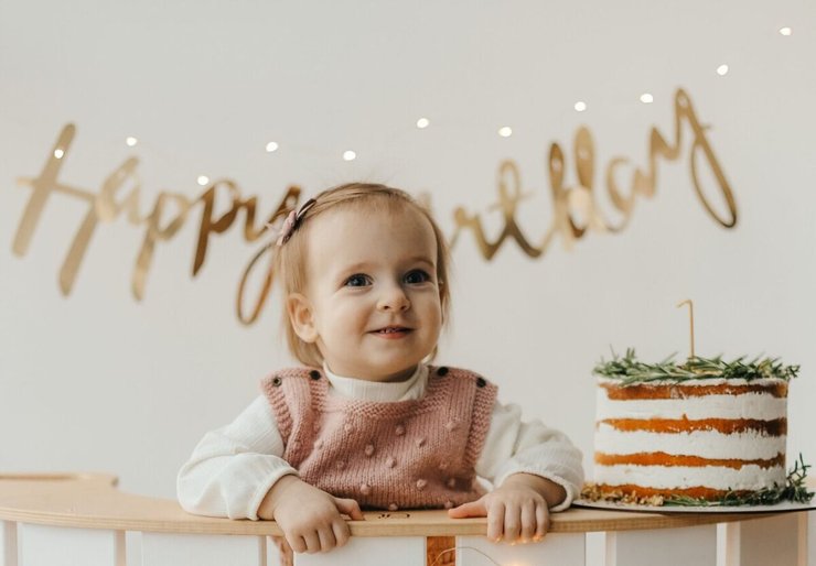 Jarig meisje op de foto met taart en happy birthday slinger