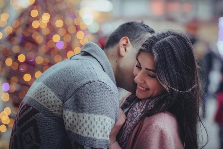 Man geeft zijn vrouw een kus in haar nek
