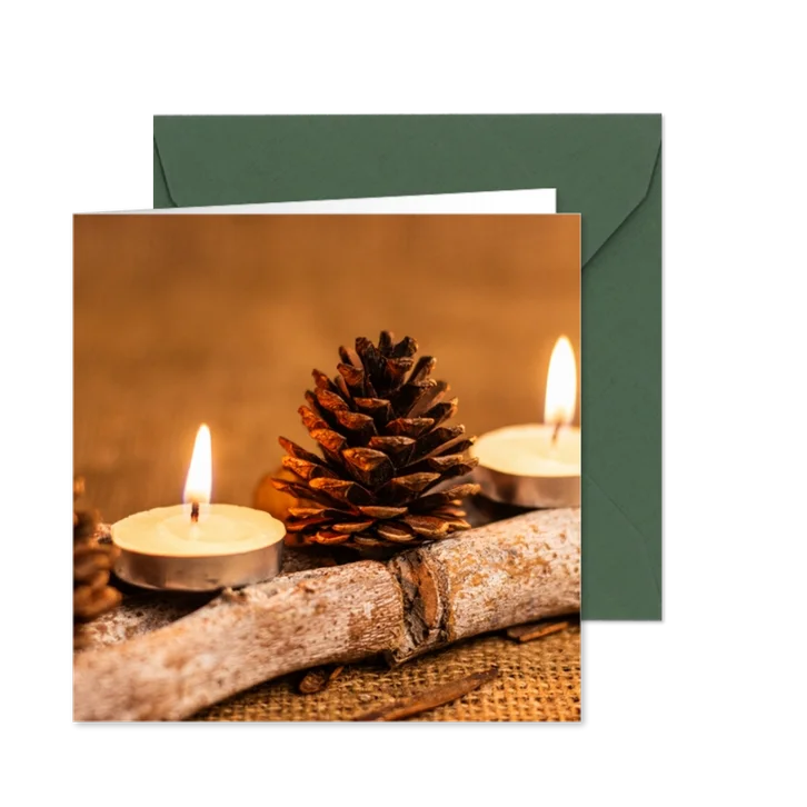 Kerstkaart met kaarsen dennenappels en houten stokje