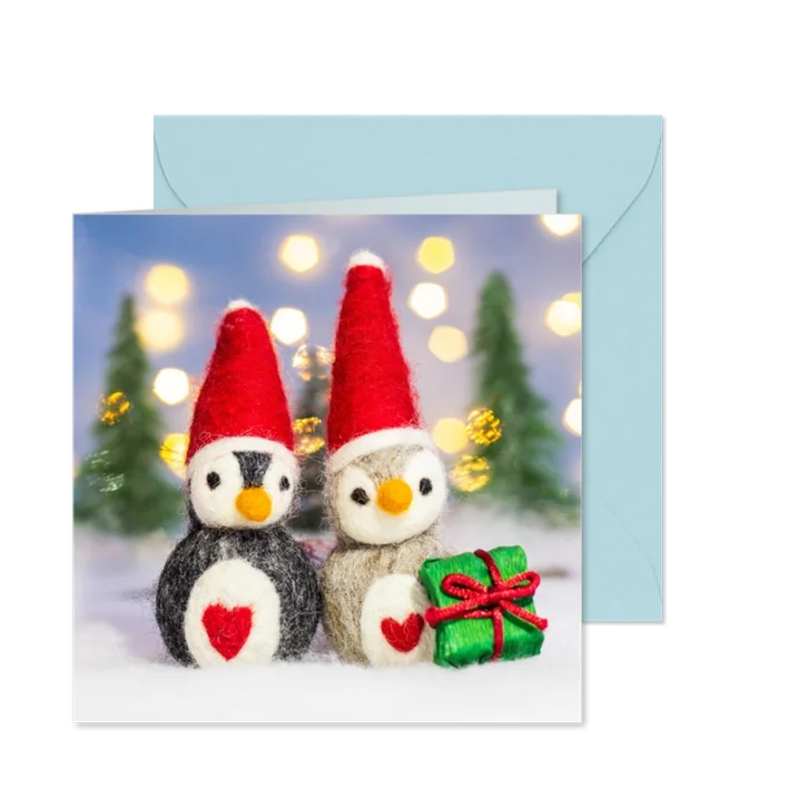 Kerstkaart met twee pinguïns in een winterlandschap 