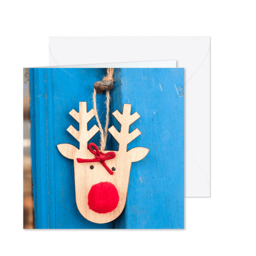 Kerstkaart met een houten rendier op een blauwe deur - Kaartimpressie