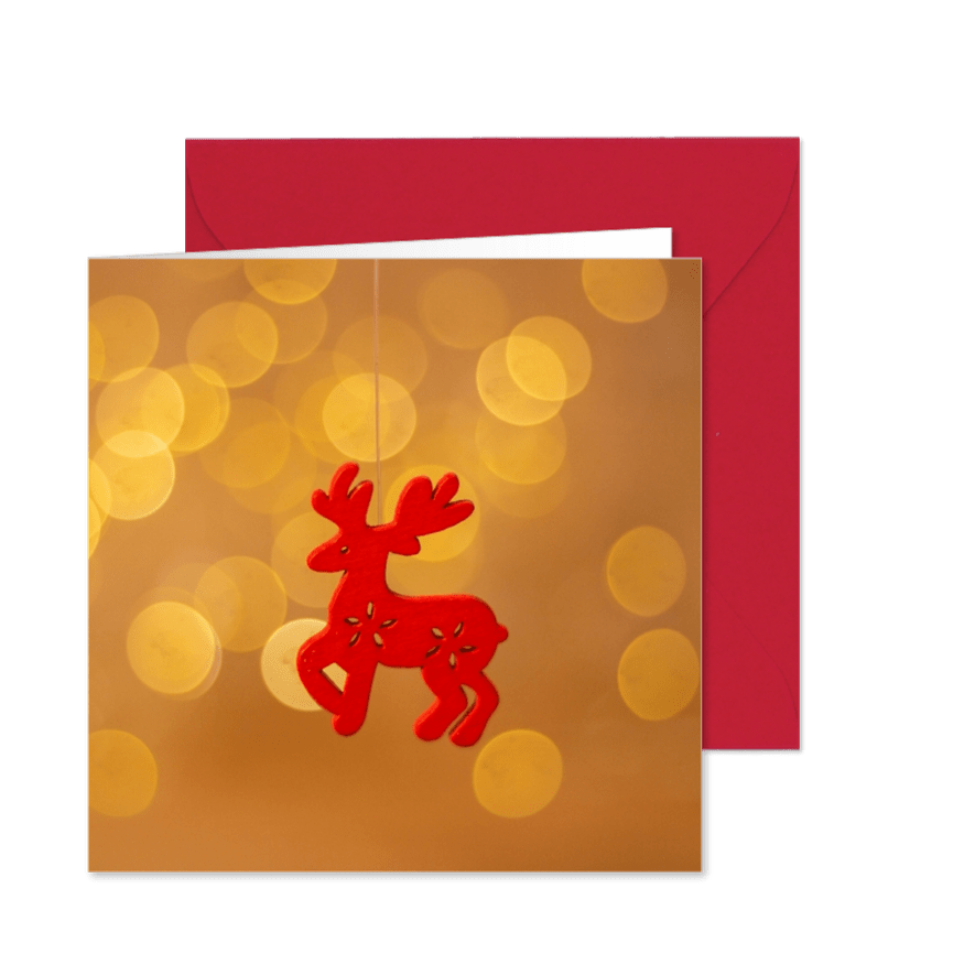 Kerstkaart met een rood rendier en vage kerstverlichting - Kaartimpressie